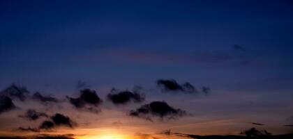 zonsondergang lucht achtergrond,mooi ochtend- zonsopkomst met kleurrijk geel, oranje, paars, blauw en wolk Aan lente, natuur panoramisch landschap gouden uur of romantisch zomer lucht foto