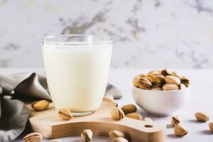 lactose vrij pistache melk in een glas en noten Aan de tafel foto