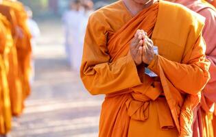 boeddhistisch monnik is staand met zijn handen gevouwen in de vorm van een lotus naar uitvoeren sommige religieus ritueel, uniform boeddhistisch monnik, boeddhistisch monnik bidden foto