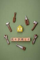 reparatie of huis verbetering gereedschap en een huis model- Aan een duidelijk achtergrond foto
