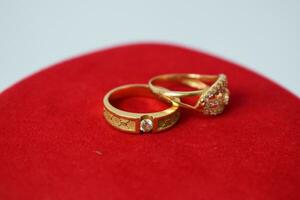 dichtbij omhoog gouden ring met diamant Aan rood tapijt achtergrond foto