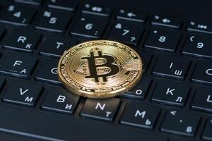 bitcoin metalen munt over het zwarte toetsenbord van computerbrieven, close-up shot foto