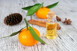 mandarijn natuurlijke olie in fles met kruiden op witte houten rustieke tafel foto