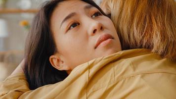 trieste jonge aziatische vrouw knuffel knuffelen omarmen met beste vriend in de woonkamer thuis ondersteunen elkaar met harde tijd met zich ziek en slecht voelen, relatieondersteuningsconcept.