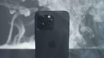 uk, Londen - september 15, 2023. 15 iphone pro Aan achtergrond van mist. actie. spectaculair promotionele video van nieuw iphone 15 over max. hoogte Aan achtergrond van rook. elegant laatste model- van iphone 15 pro Aan foto