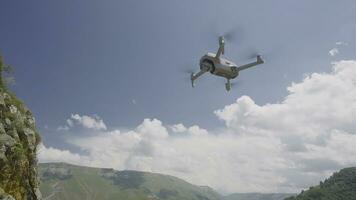 quadcopter vliegend Aan achtergrond van bergen en lucht. actie. professioneel quadcopter voor het schieten terwijl reizend. quadcopter stijgt en duurt afbeeldingen van berg landschappen foto
