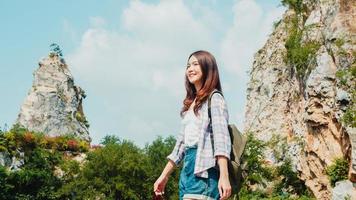 vrolijke jonge reiziger Aziatische dame met rugzak wandelen op het bergmeer. Koreaans tienermeisje geniet van haar vakantieavontuur en voelt zich gelukkig in vrijheid. levensstijl reizen en ontspannen in vrije tijd concept.
