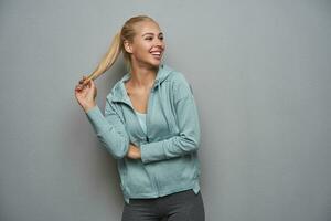 gelukkig mooi jong sportief blond vrouw met paardenstaart kapsel op zoek blij terzijde foto