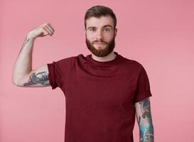 jong knap rood gebaard Mens in blanco t-shirt, staat over- roze achtergrond, looks koel, genieten zichzelf en demonstreren krachtig, looks Bij de camera en glimlachen foto