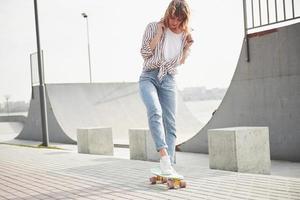 een jonge sportvrouw die op een skateboard in een park rijdt. foto