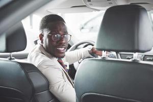 jonge zwarte zakenman proefrit nieuwe auto. rijke afro-amerikaanse man
