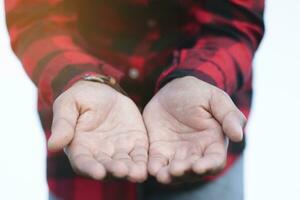 een Mens in een geruit overhemd is Holding uit een hand, bevrijding concept, delen, soort geest. foto