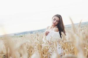 mooi meisje in een tarweveld in een witte jurk, een perfect plaatje in de stijl lifestyle foto