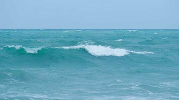 visie van zee golven Aan de strand van tropisch zeeën in Thailand. sterk zee golven Botsing naar kust in de regenachtig seizoen. mooi zee golven met schuim van blauw en turkoois kleur. foto