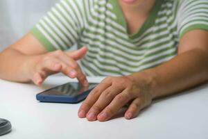 richten vinger Bij mobiel telefoon scherm dichtbij omhoog. detailopname van mooi Aziatisch vrouw vasthouden, gebruik makend van en op zoek Bij smartphone. foto