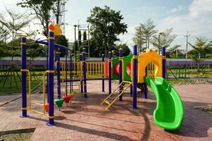 kleurrijk speelplaats Aan werf in de park. tunnel en schuif voor kinderen in openbaar park. foto