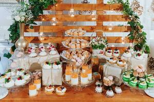 feestelijk toetje tafel met snoepgoed. bruiloft snoep bar, divers taarten, chocolaatjes Aan staat. foto