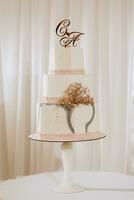 een heerlijk bruiloft. roze drieledig taart versierd met bloemen. snoep bar voor een banket. viering concept. modieus desserts. tafel met snoepgoed, snoepjes. fruit foto