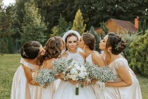 een groep van mooi Dames in bij elkaar passen jurken zijn lachend, vieren, en hebben pret samen. vrienden van de bruid in roze jurken vieren de bruiloft samen met de bruid foto