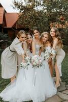 groep van mooi Dames in identiek jurken lachend, vieren en hebben pret samen. vrienden van de bruid vieren de bruiloft samen met de bruid in natuur foto