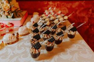 een zoet tafel Bij een bruiloft. tafel met cakes en snoepgoed Bij de festival. verjaardag snoepgoed foto