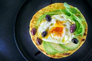 avocado pannenkoek met gebakken ei Aan top. heerlijk gezond ontbijt. foto