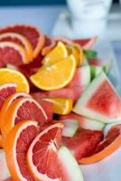 dichtbij omhoog van verschillend soorten van citrus fruit Aan een wit bord. foto