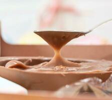 chocola snoepjes in kom Aan wit houten tafel, detailopname foto