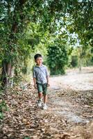 gelukkige jongen die alleen in het park speelt foto