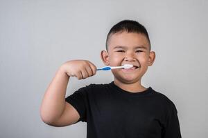 kleine jongen die zijn tanden poetst in studiofoto foto