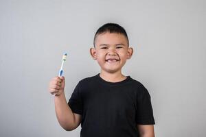 kleine jongen die zijn tanden poetst in studiofoto foto