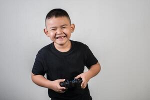 gelukkige jongen speel spelcomputer met een controller in studiofoto foto
