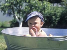mooie babyjongen in kinderbad poseren fotograaf