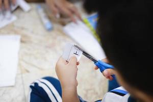 kinderen leren een schaar te gebruiken om papier te knippen. foto