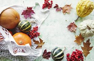 herfstcompositie met diverse pompoenen in eco string bag foto