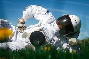 futuristische astronaut in een helm op een groen gazon foto