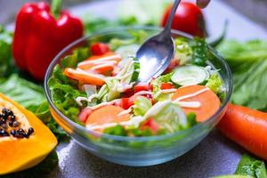 gezonde voedingskeuzes om schoon te eten, fruit, groenten, zaden, bladgroenten op grijs beton