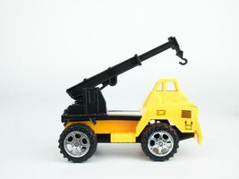 speelgoed vrachtwagen kraan op witte achtergrond, engineering bouwconcept foto