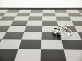 diamanten ring met koning en koningin schaken op het bord, bruiloft concept. foto