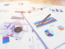 zakelijke rapportgrafiek en financiële grafiekanalyse met dollargeld, pen en kompas op tafel foto