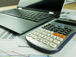 zakelijke rapportgrafiek en financiële grafiekanalyse met notitieboekje en rekenmachine op tafel