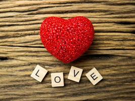 bovenaanzicht van rood hart op houten blackground, liefdeswoord in houten kubus, valentijnsdag foto