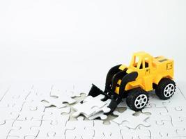 speelgoedbulldozer met puzzel op witte achtergrond foto