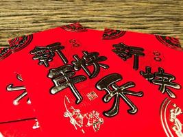 rode envelop op houten achtergrond met februari voor cadeau chinees nieuwjaar. Chinese tekst op envelop betekent gelukkig chinees nieuwjaar foto