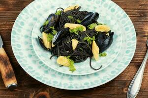 zwart spaghetti pasta linguine met mosselen. foto