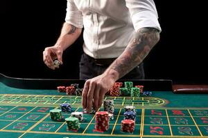 een detailopname levendig beeld van groen casino tafel met roulette, met de handen van croupier en veelkleurig chips. foto