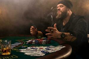 gebaard Mens met sigaar en glas zittend Bij poker tafel in een casino. gokken, spelen kaarten en roulette. foto