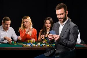poker spelers in casino met kaarten en chips Aan zwart achtergrond foto