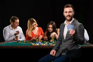 poker spelers in casino met kaarten en chips Aan zwart achtergrond foto