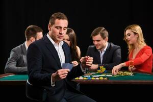 poker spelers in casino met kaarten en chips Aan zwart achtergrond foto